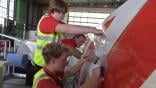 technicians applying film to aircraft